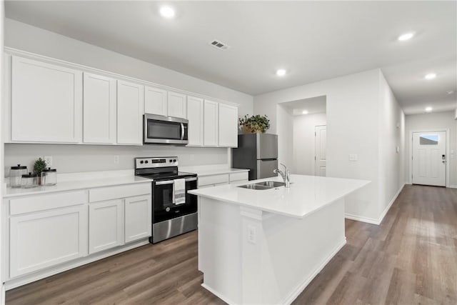 1300 Bates St, Gentry, AR 72734 - kitchen featuring stainless steel appliances, a kitchen island with sink, white cabinets, wood finished floors, and recessed lighting