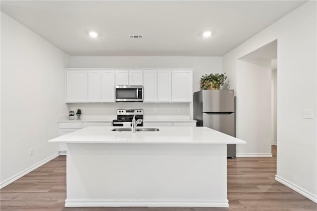 1300 Bates St, Gentry, AR 72734 - kitchen with appliances with stainless steel finishes, a sink, a kitchen island with sink, light countertops, and recessed lighting