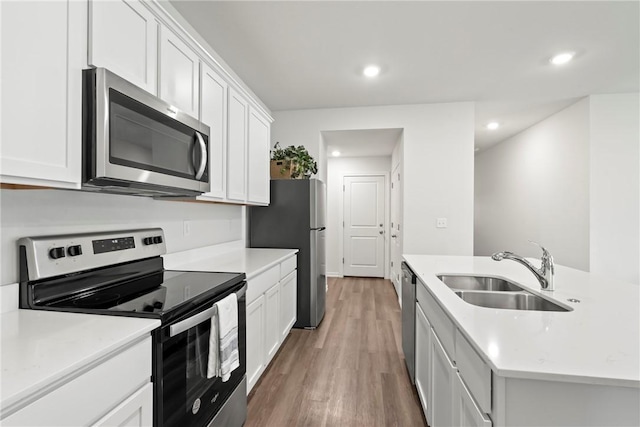 1300 Bates St, Gentry, AR 72734 - kitchen with appliances with stainless steel finishes, a sink, white cabinetry, recessed lighting, and light wood-style floors