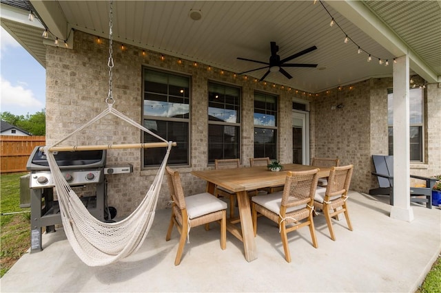 view of patio with a ceiling fan, outdoor dining space, and fence