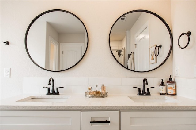 full bath featuring double vanity, a sink, and backsplash