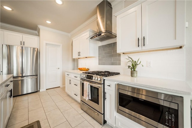 kitchen featuring white cabinets, ornamental molding, wall chimney exhaust hood, and appliances with stainless steel finishes