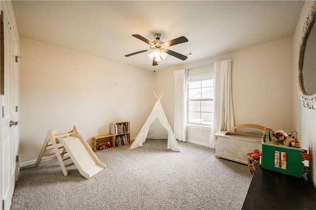recreation room featuring carpet, a ceiling fan, and baseboards