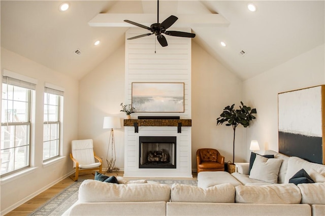 living room with a fireplace, lofted ceiling with beams, ceiling fan, baseboards, and wood finished floors
