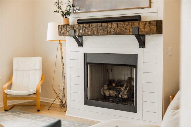 details featuring a fireplace, wood finished floors, and baseboards