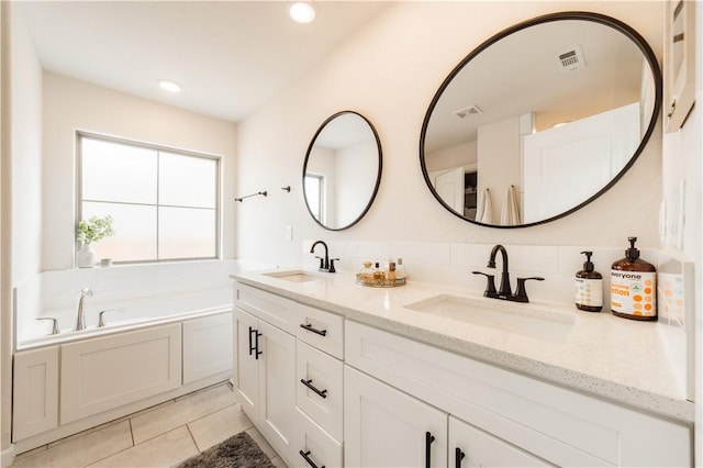 full bathroom featuring tile patterned floors, visible vents, a garden tub, and a sink
