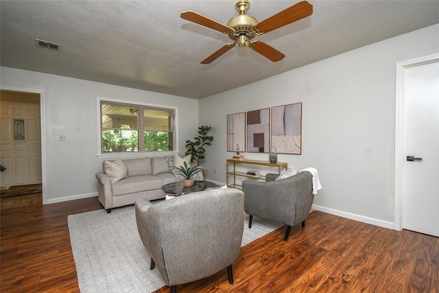 living area with visible vents, ceiling fan, dark wood-style floors, and baseboards
