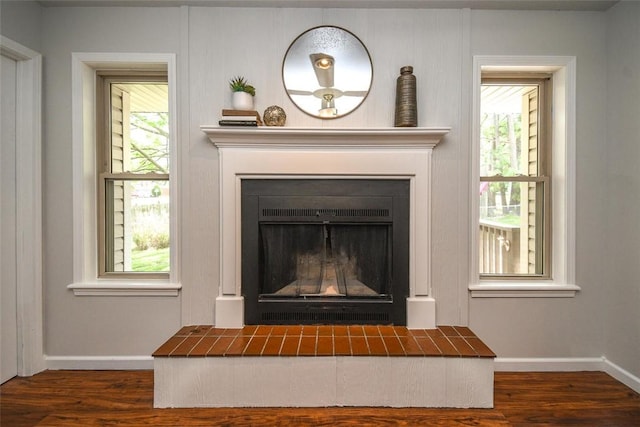 interior details with a fireplace, wood finished floors, and baseboards