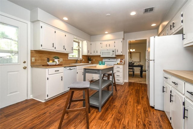 kitchen featuring visible vents, white cabinets, decorative backsplash, and white appliances