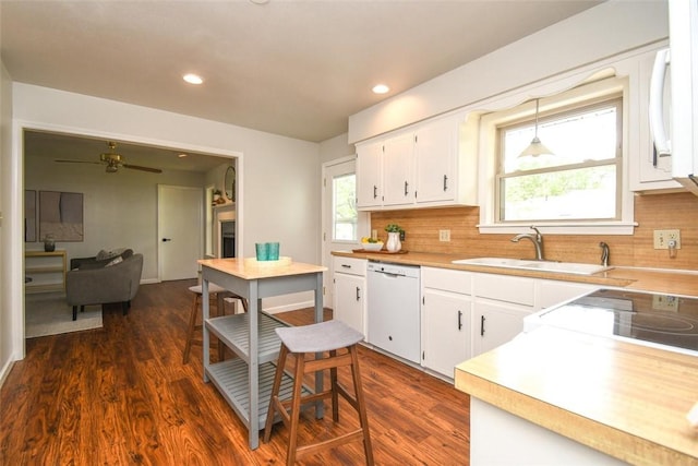 kitchen with decorative backsplash, light countertops, dishwasher, and a sink