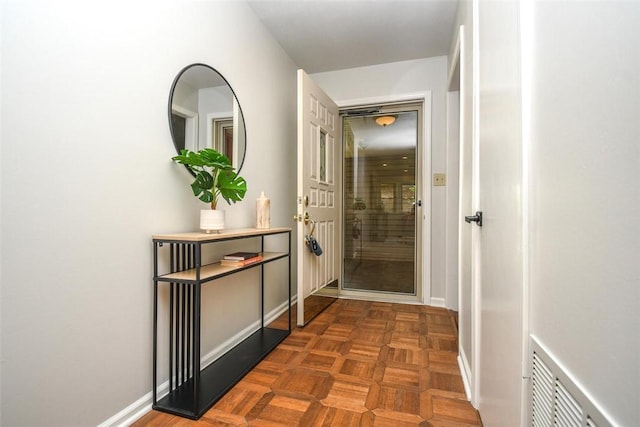 corridor featuring visible vents and baseboards