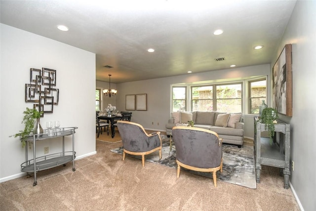 living area featuring a healthy amount of sunlight, visible vents, an inviting chandelier, and carpet floors