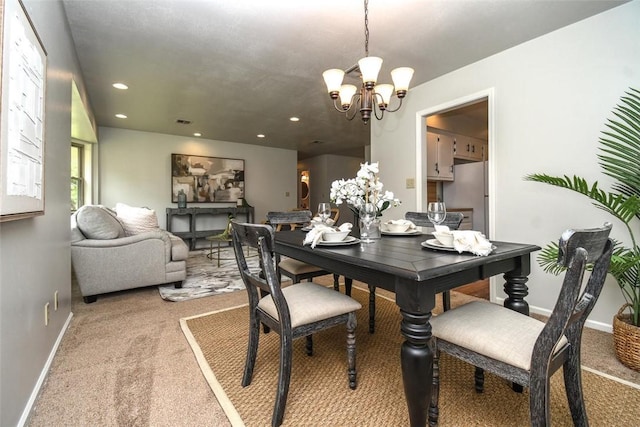 dining space featuring light colored carpet, a chandelier, recessed lighting, and baseboards