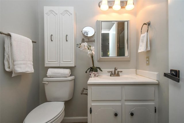 bathroom featuring vanity, toilet, and baseboards