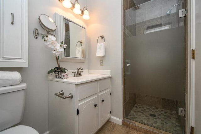 bathroom featuring a shower stall, vanity, tile patterned floors, toilet, and baseboards