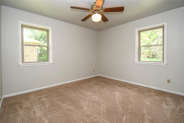 empty room featuring a ceiling fan, carpet floors, and baseboards