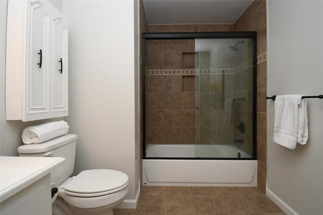 full bathroom featuring tile patterned floors, toilet, vanity, baseboards, and bath / shower combo with glass door