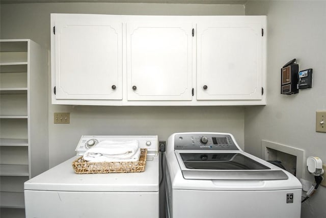 clothes washing area featuring washer and dryer and cabinet space