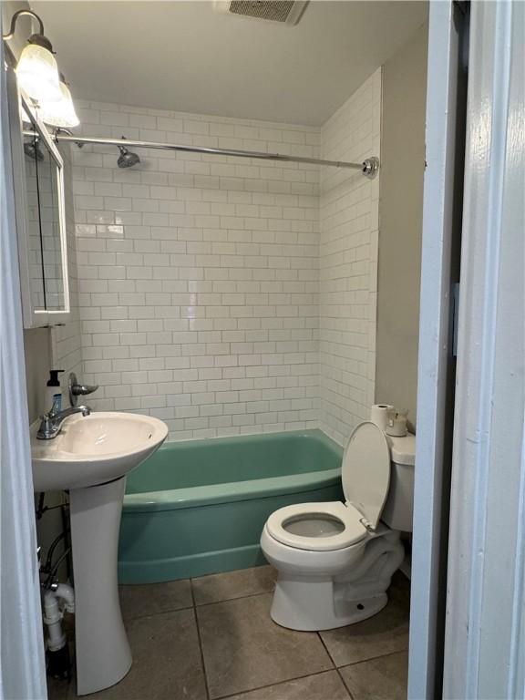 full bathroom featuring shower / tub combination, visible vents, toilet, and tile patterned flooring