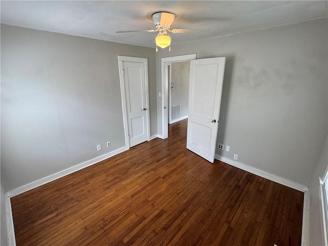 spare room with wood finished floors, visible vents, ceiling fan, and baseboards