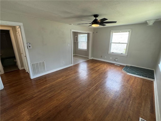 unfurnished room featuring baseboards, visible vents, wood finished floors, and a ceiling fan