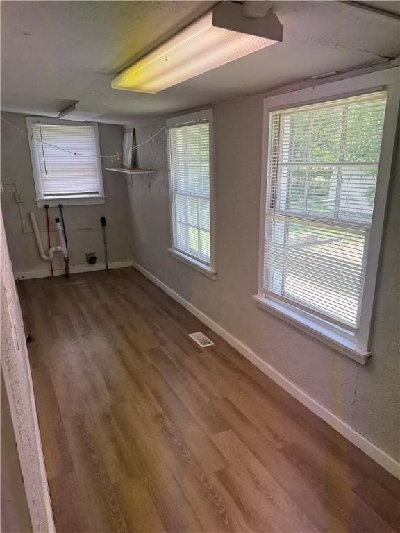 interior space with visible vents, wood finished floors, and baseboards