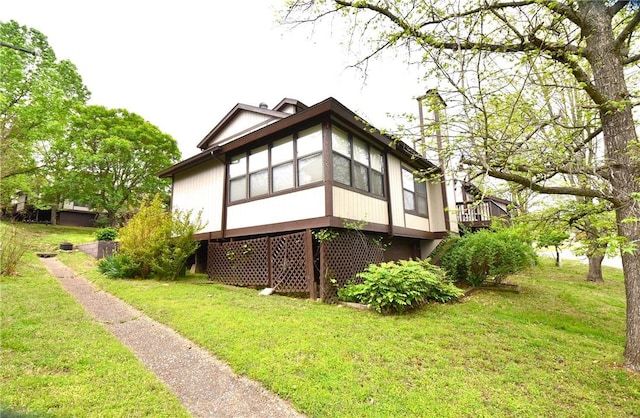 rear view of property featuring a yard and a sunroom