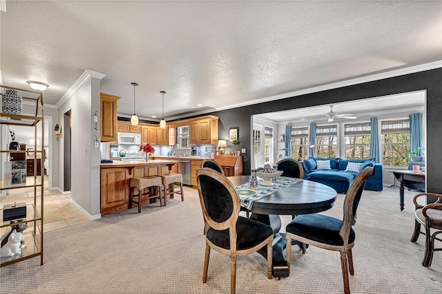 dining area featuring crown molding, a ceiling fan, baseboards, a textured ceiling, and light colored carpet