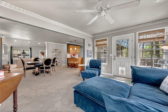 carpeted living area with a healthy amount of sunlight, a ceiling fan, and baseboards