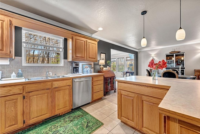 kitchen with a sink, light countertops, plenty of natural light, dishwasher, and decorative light fixtures