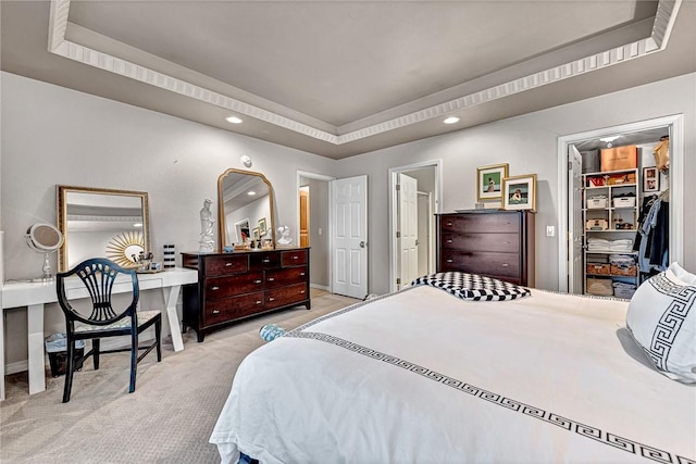 carpeted bedroom with baseboards, a spacious closet, a raised ceiling, and recessed lighting