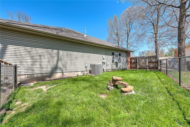 rear view of house featuring central air condition unit, crawl space, a fenced backyard, cooling unit, and a lawn