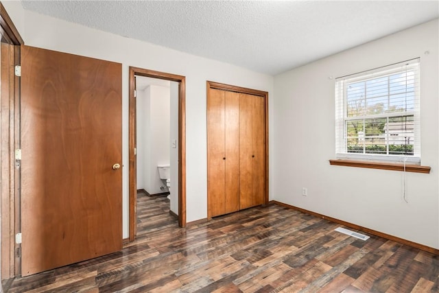 1622 2nd St, Westville, OK 74965 - unfurnished bedroom featuring a closet, dark wood-type flooring, visible vents, baseboards, and a textured ceiling