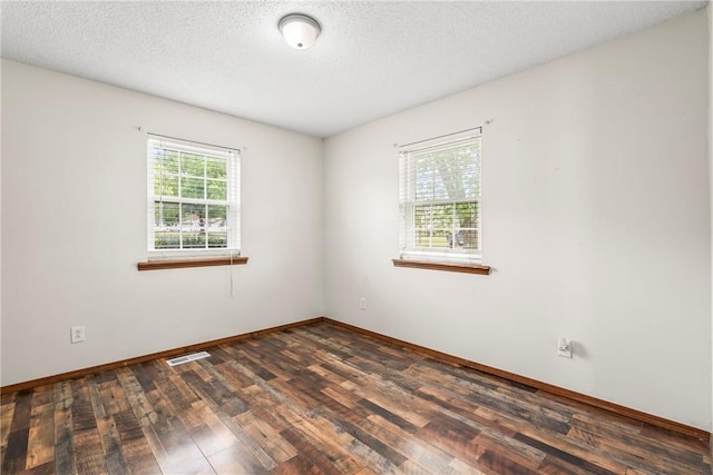 1622 2nd St, Westville, OK 74965 - unfurnished room with baseboards, visible vents, a textured ceiling, and dark wood-style flooring
