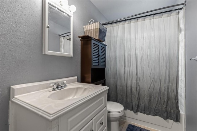 full bath featuring toilet, shower / tub combo with curtain, a textured wall, and vanity