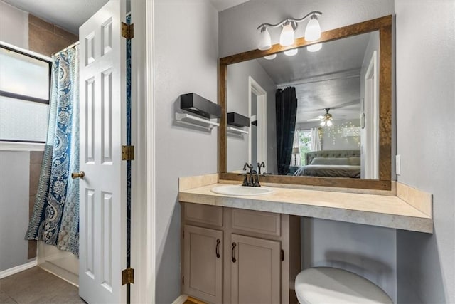 ensuite bathroom featuring baseboards, vanity, a ceiling fan, ensuite bath, and tile patterned flooring