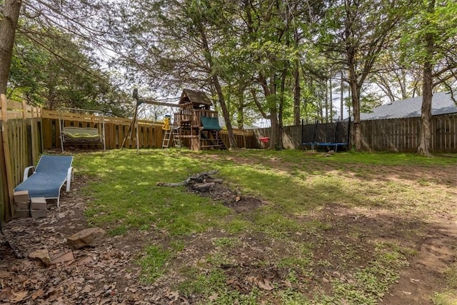 view of yard featuring a playground, a fenced backyard, and a trampoline
