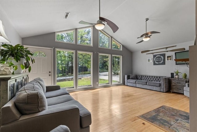 living area with visible vents, wood finished floors, ceiling fan, and high vaulted ceiling