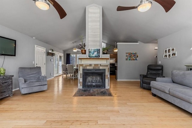 living area featuring ceiling fan, vaulted ceiling, wood finished floors, and baseboards