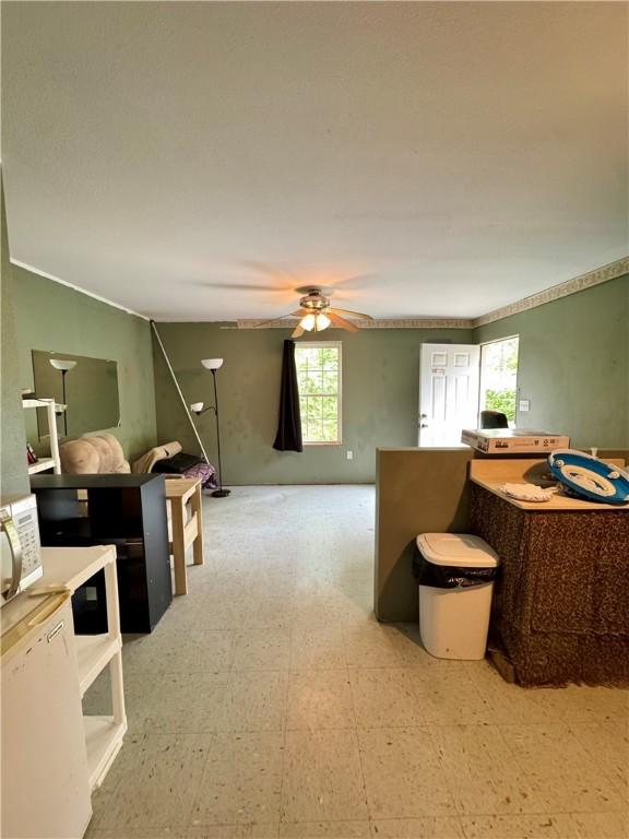 interior space with light floors and ceiling fan