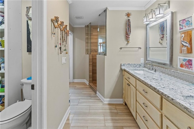 bathroom with baseboards, a shower stall, crown molding, and vanity