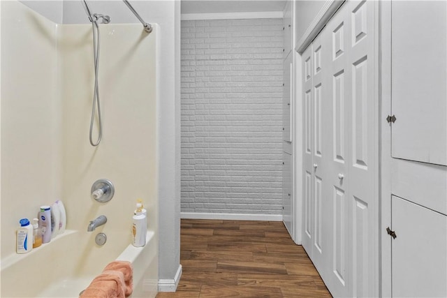 bathroom with ornamental molding, shower / bath combination, wood finished floors, and baseboards
