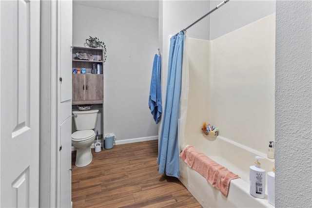 full bathroom with baseboards, shower / bath combo, wood finished floors, and toilet