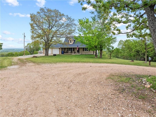 view of front facade with covered porch, a front yard, driveway, and an attached garage