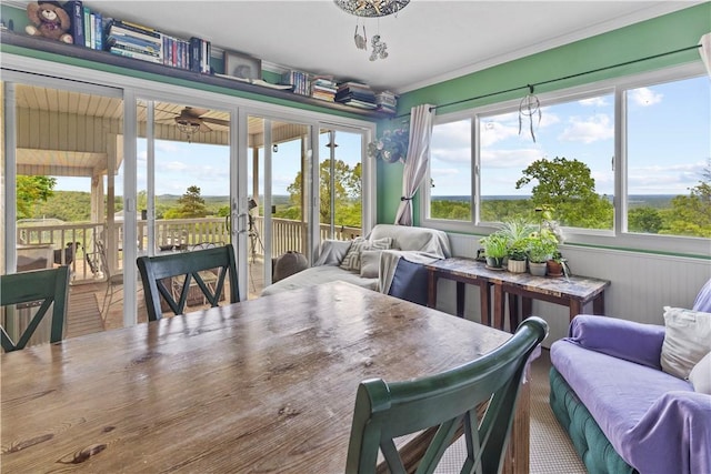 sunroom with an outdoor living space, outdoor dining area, and ornamental molding