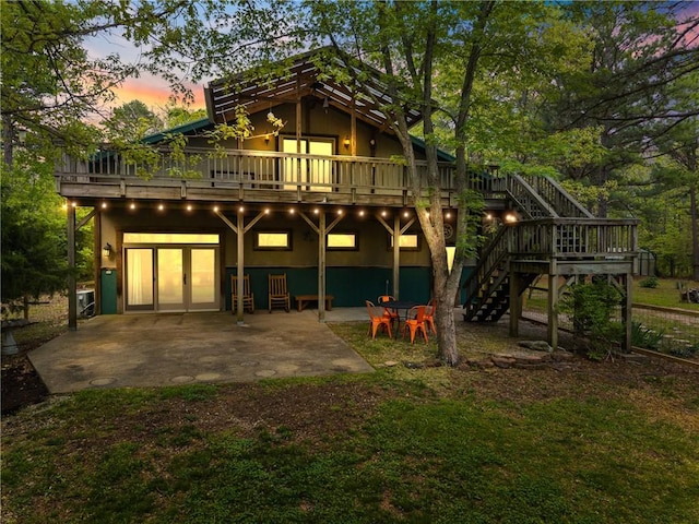 rear view of property with a deck, a patio area, and stairs