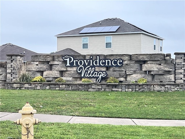 community sign featuring a lawn