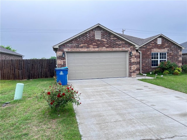 ranch-style house featuring a front yard, brick siding, concrete driveway, an attached garage, and fence