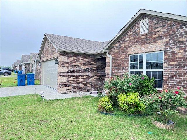 ranch-style home with driveway, roof with shingles, an attached garage, brick siding, and a front lawn