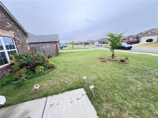 view of yard featuring fence and a residential view